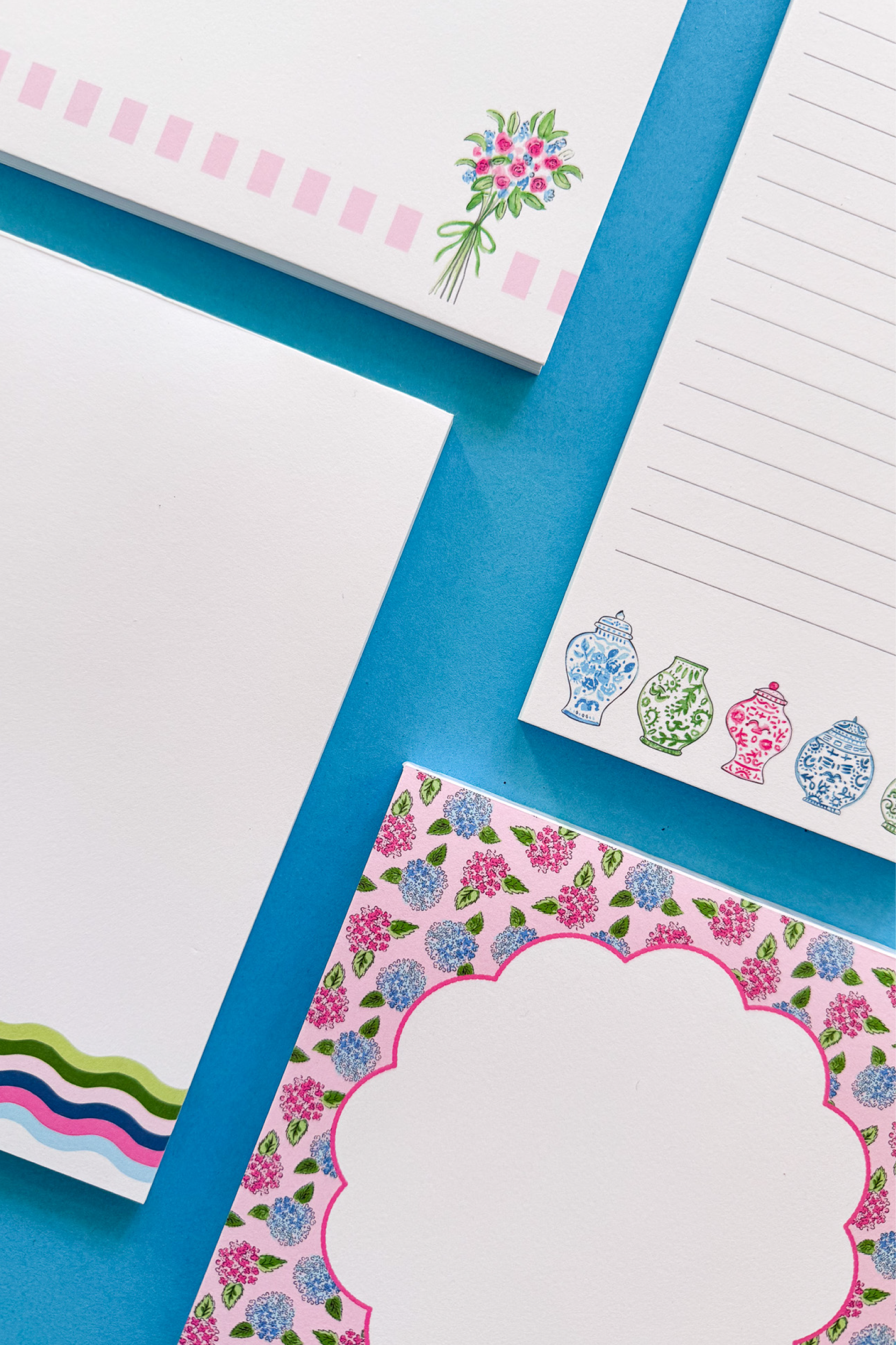 Assorted stationery items with floral designs on a blue background