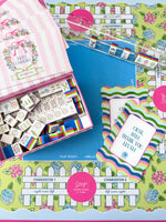 Colorful Mahjong tiles, box, and game play accessories set on a colorful mat
