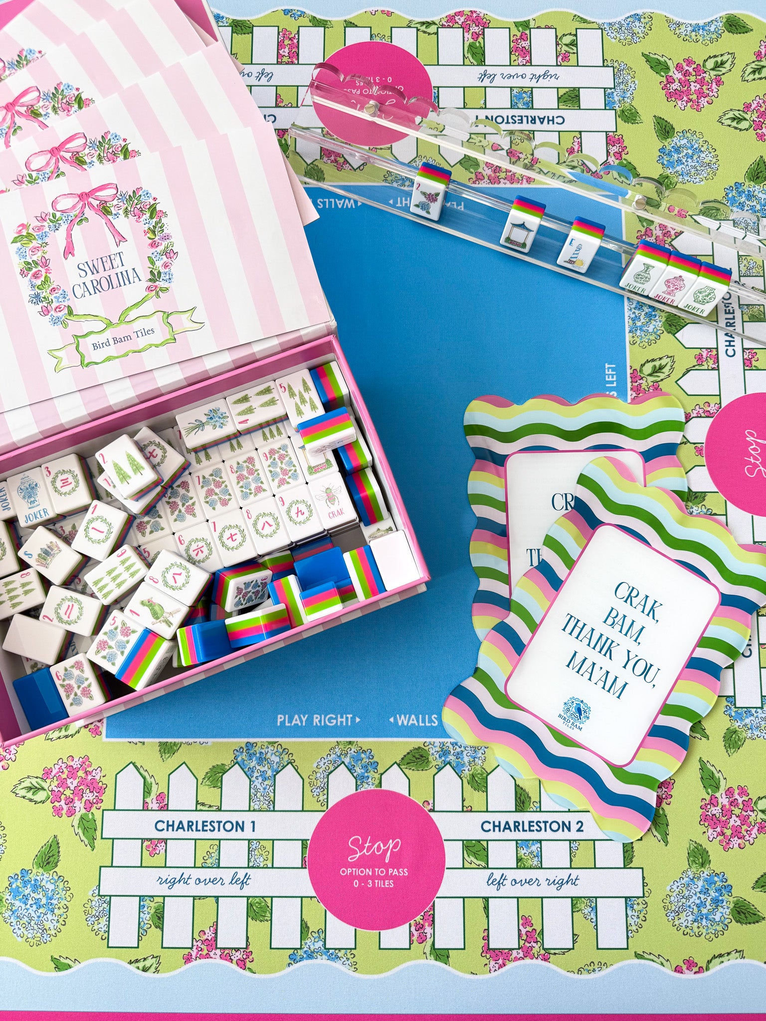 Colorful Mahjong tiles, box, and game play accessories set on a colorful mat