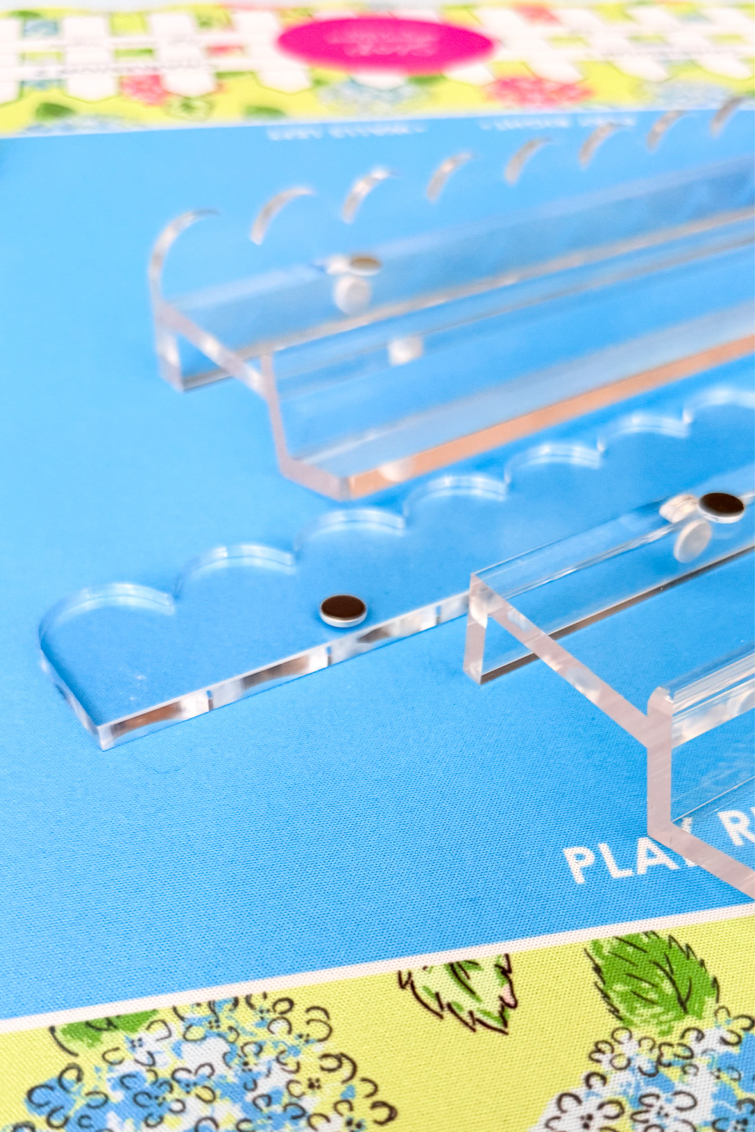 Clear acrylic racks and pushers for mahjong games on a colorful floral mat