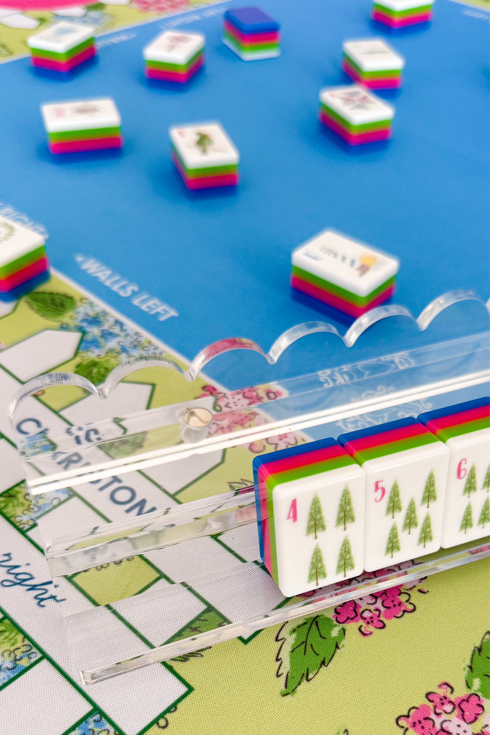 Close-up of a scalloped acrylic rack with colorful tiles on a mahjong mat background