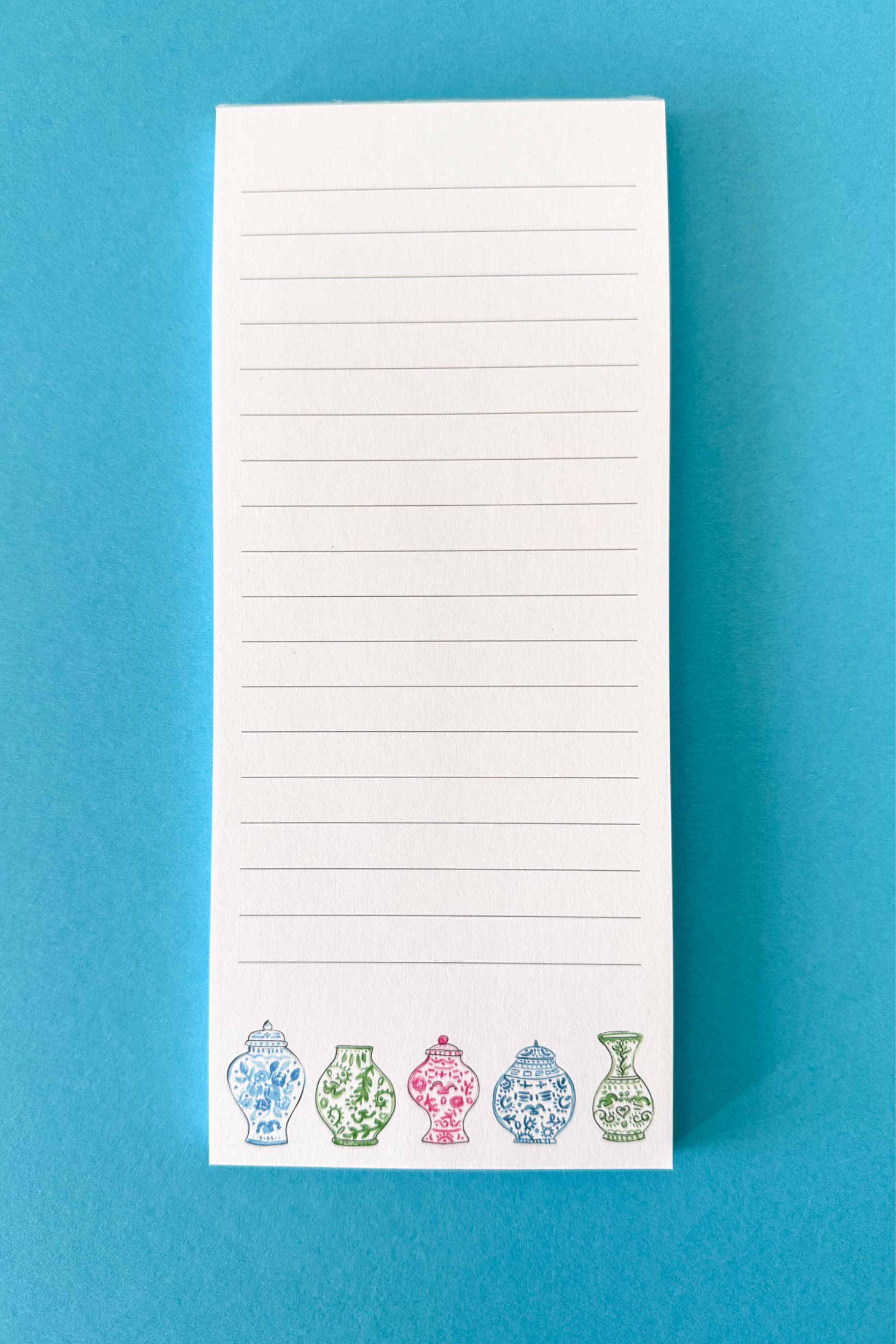 Lined notepad with ginger jar designs from the Sweet Carolina Tile Set at the bottom of the paper on a blue background