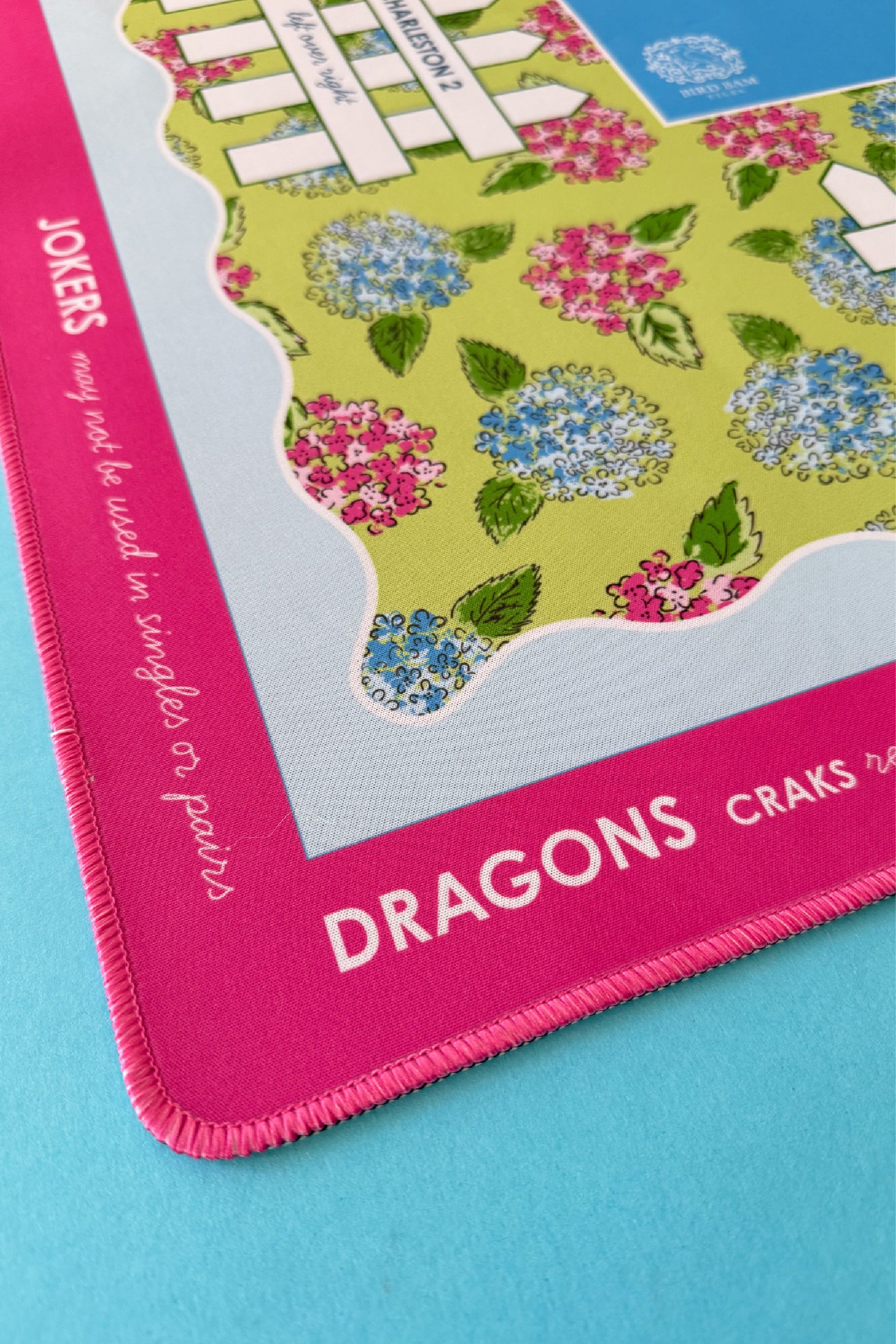 Details of a colorful Mahjong mat with floral design and text on a blue background